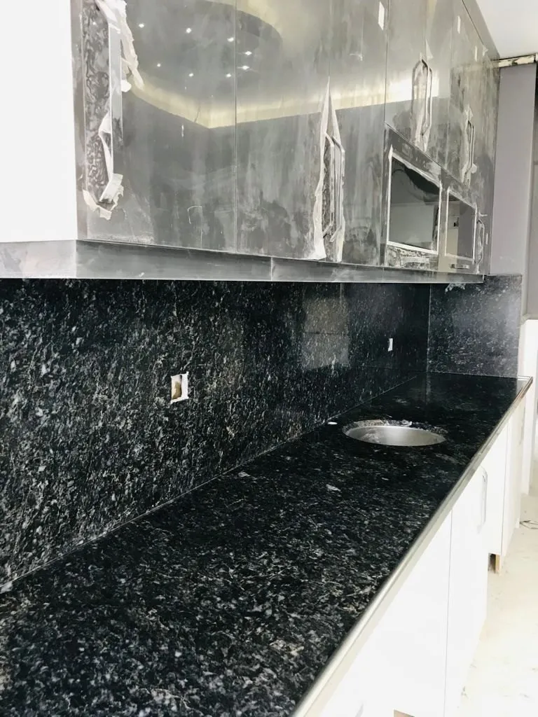 Black marble kitchen countertop and backsplash, installed