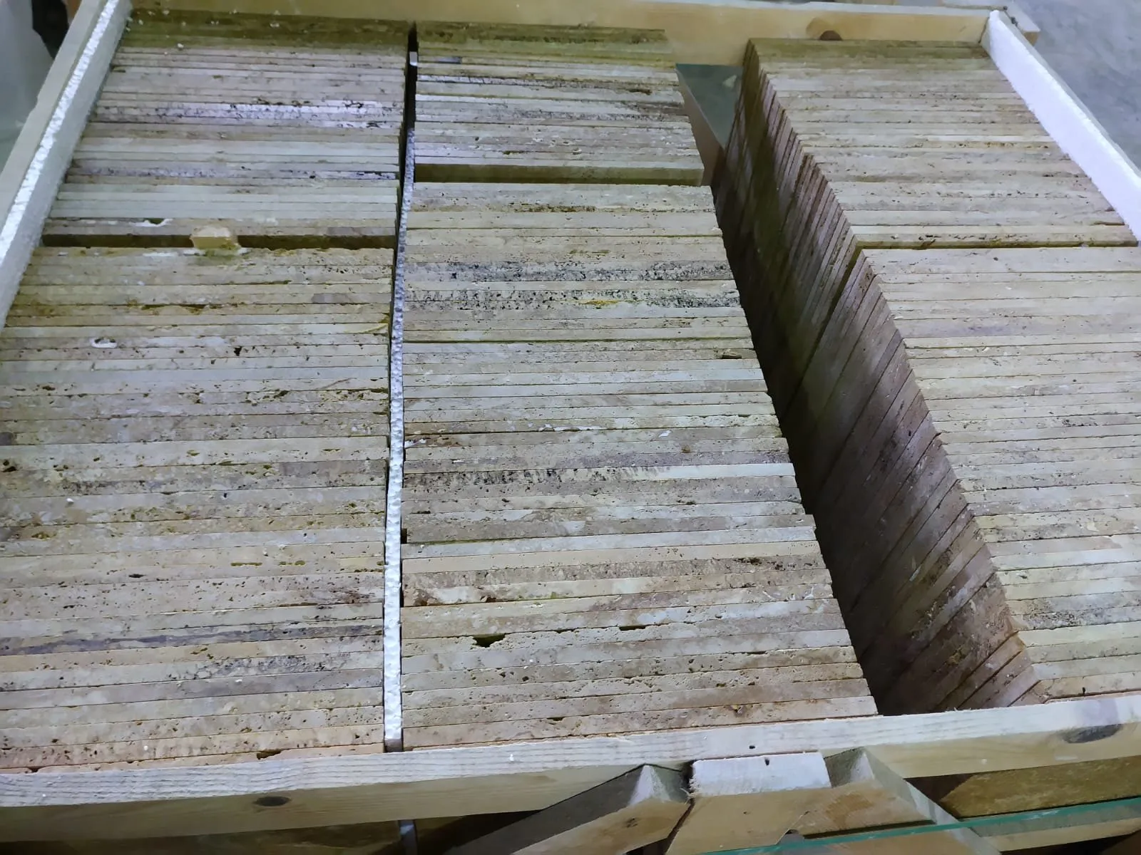 Travertine tiles standing on edge inside an export crate